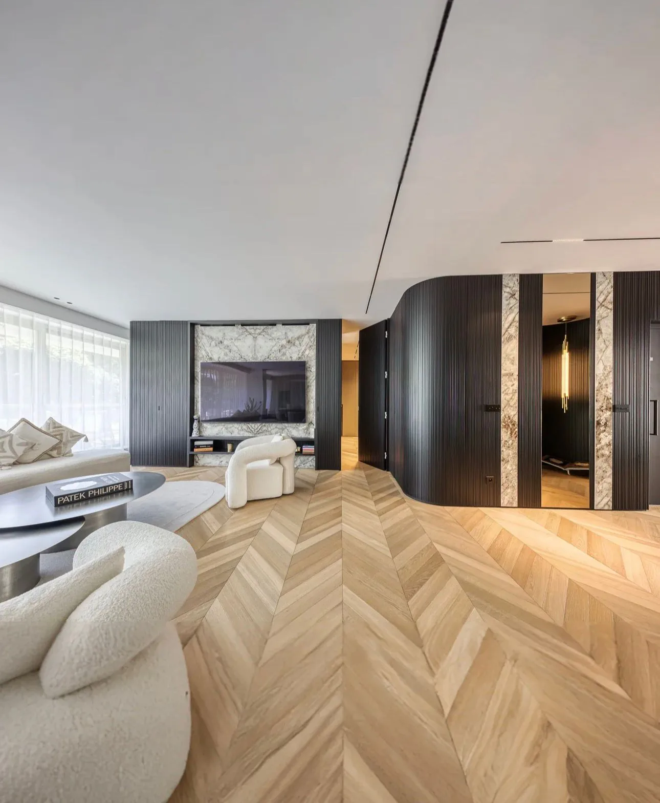 Séjour rénové : parquet en point de Hongrie, meuble bas en bois sombre et encadrements de marbre.